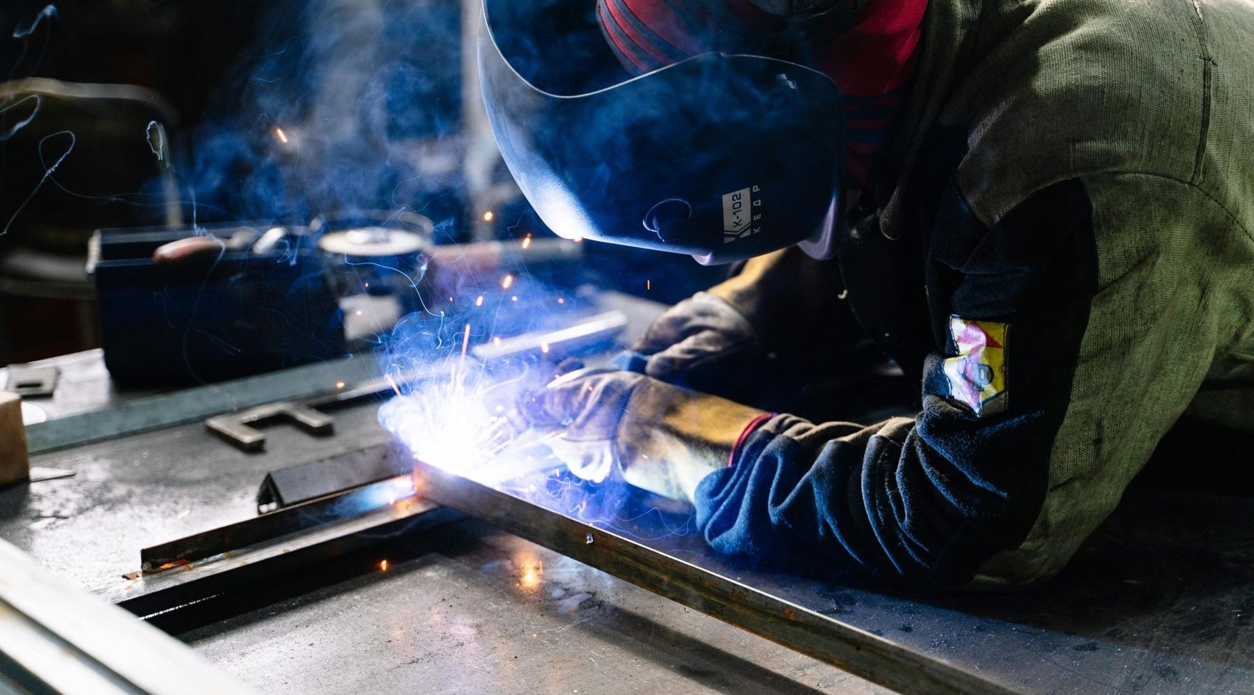Saldatore al lavoro su un banco di carpenteria metallica