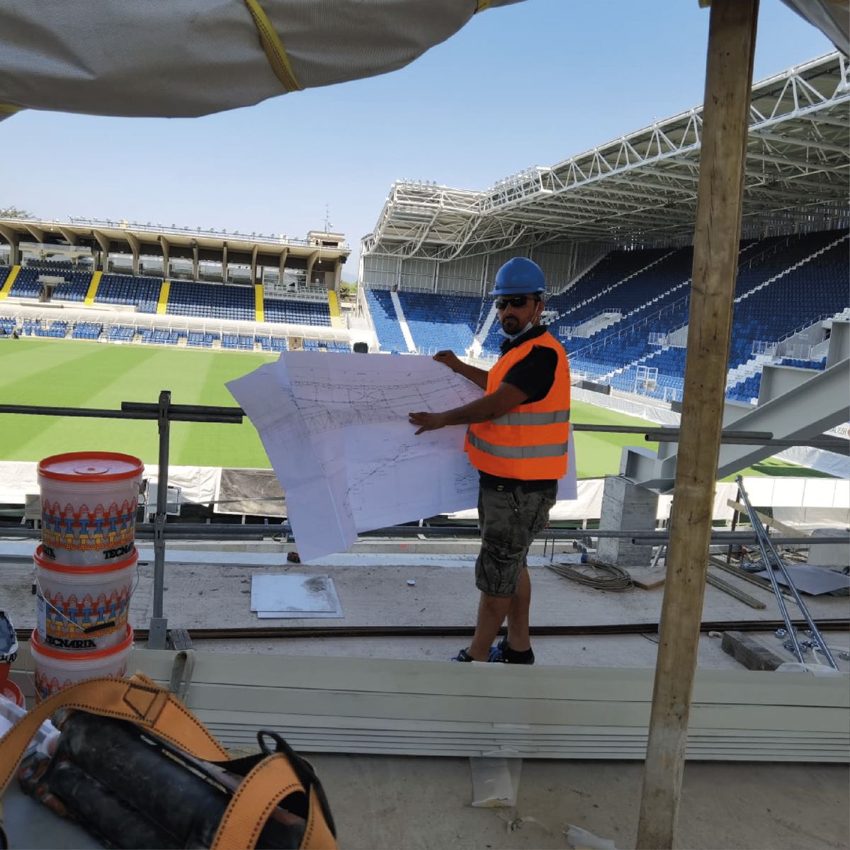 Tecnico Kajo Costruzioni consulta il progetto in cantiere sulla tribuna dello stadio di Bergamo